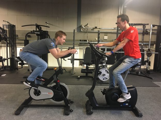 Hometrainer en spinningfiets tegenover elkaar